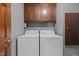Convenient laundry area with washer, dryer, and storage cabinets for organization at 323 E Stratford Dr, Henderson, NC 27537