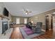 Inviting living room features hardwood floors, brick fireplace, and comfortable seating with ceiling fan at 323 E Stratford Dr, Henderson, NC 27537