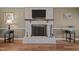 Charming living room showcasing brick fireplace with wooden mantel and hardwood flooring at 323 E Stratford Dr, Henderson, NC 27537
