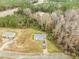 An aerial view showcasing the property with mature trees, road access, and other homes nearby at 35 Golden Poppy Ln, Youngsville, NC 27596