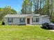 Charming single-story home featuring a red front door, well-manicured lawn, and attached garage at 35 Golden Poppy Ln, Youngsville, NC 27596