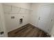 Functional laundry room with wood-look floors, wire shelving, and utility connections for appliances at 37 Furley St., Homesite 38, Sanford, NC 27330