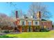 Rear exterior of the brick home with a deck, multiple windows and doors, and a view of the backyard at 382 Wimbledon Dr, Roxboro, NC 27573