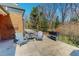 An outdoor patio with seating overlooks a landscaped backyard on a sunny day at 382 Wimbledon Dr, Roxboro, NC 27573