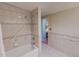 Bathroom featuring tiled walls, shower with tub, and a doorway that leads to another area at 382 Wimbledon Dr, Roxboro, NC 27573