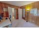 Bedroom with wood paneled walls, open bathroom access, and ample natural light at 382 Wimbledon Dr, Roxboro, NC 27573