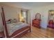 A bedroom features wood floors, a four poster bed, and light striped wallpaper at 382 Wimbledon Dr, Roxboro, NC 27573