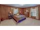 A bedroom with carpet features wood paneling, a paisley bedspread, and two windows at 382 Wimbledon Dr, Roxboro, NC 27573
