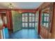 Grand foyer showcasing wood paneling, slate floors, a decorative mirror, and double doors with glass panels at 382 Wimbledon Dr, Roxboro, NC 27573