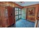 Inviting foyer featuring wood paneling, slate flooring, and a charming arched doorway with glass panes at 382 Wimbledon Dr, Roxboro, NC 27573