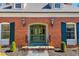 Charming home featuring a green front door flanked by matching shutters and classic lighting at 382 Wimbledon Dr, Roxboro, NC 27573