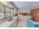 Well-lit kitchen featuring white cabinetry, an island with cooktop, and views to an adjacent room at 382 Wimbledon Dr, Roxboro, NC 27573