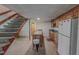 Basement kitchen includes a wooden staircase, island, cabinets, sink, and white refrigerator at 382 Wimbledon Dr, Roxboro, NC 27573