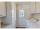Bright laundry room with window, white cabinets, and modern washer and dryer at 382 Wimbledon Dr, Roxboro, NC 27573