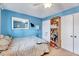 Bedroom with light blue walls, mirror, bookshelf and closet at 3923 Wendy Ln, Raleigh, NC 27606