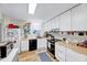 Well-lit kitchen featuring white cabinets, butcher block countertops, and stainless steel appliances at 3923 Wendy Ln, Raleigh, NC 27606
