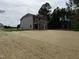 Exterior back view of a two-story home with a covered porch and a spacious straw-covered backyard at 4012 Kingcraig Ln, Zebulon, NC 27597