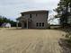 Exterior back view of a two-story home with a covered porch and a spacious straw-covered backyard at 4012 Kingcraig Ln, Zebulon, NC 27597