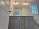 Stylish bathroom with gray vanity, mirror, and modern lighting fixtures at 4012 Kingcraig Ln, Zebulon, NC 27597