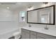 Bathroom featuring a dual sink vanity, a window, and a tub with white subway tile at 4012 Kingcraig Ln, Zebulon, NC 27597