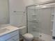 Bathroom featuring a white vanity, toilet, and a glass-enclosed shower with built-in shelving at 4012 Kingcraig Ln, Zebulon, NC 27597