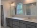 Bathroom featuring double sinks, quartz countertops, gray cabinets, and framed mirrors at 4012 Kingcraig Ln, Zebulon, NC 27597