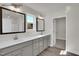 A double vanity sink bathroom with grey cabinets, lighting, mirrors, and a closet at 4012 Kingcraig Ln, Zebulon, NC 27597