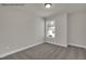 Bright carpeted bedroom with neutral walls and trim and a view of the front yard at 4012 Kingcraig Ln, Zebulon, NC 27597