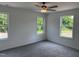 Bright, airy bedroom featuring a ceiling fan, carpet, and multiple windows with green views at 4012 Kingcraig Ln, Zebulon, NC 27597