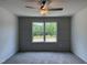 Bedroom with gray walls, wall trim, a ceiling fan, and a window overlooking the outside landscape at 4012 Kingcraig Ln, Zebulon, NC 27597