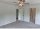 Bedroom featuring neutral carpeting, a ceiling fan, and doorways leading to a closet and bathroom at 4012 Kingcraig Ln, Zebulon, NC 27597