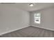 Bright carpeted bedroom featuring neutral walls and trim with a window overlooking the yard at 4012 Kingcraig Ln, Zebulon, NC 27597