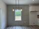 A dining area shows a window with natural light, modern lighting, and light gray paneled wall at 4012 Kingcraig Ln, Zebulon, NC 27597