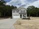 Charming two-story home featuring a two-car garage, stone accents, and a covered front porch in a wooded area at 4012 Kingcraig Ln, Zebulon, NC 27597