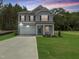 Beautiful two-story home with gray siding, stone accents, attached garage, and well-manicured lawn at 4012 Kingcraig Ln, Zebulon, NC 27597