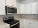 Stainless steel appliances complement this modern kitchen with white cabinetry and neutral backsplash at 4012 Kingcraig Ln, Zebulon, NC 27597