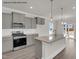 An island kitchen with stainless steel appliances and grey cabinets at 4012 Kingcraig Ln, Zebulon, NC 27597