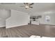 Spacious living room with hardwood floors, a ceiling fan, and an adjacent kitchen and stairs at 4012 Kingcraig Ln, Zebulon, NC 27597