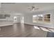 Open living area with hardwood floors, backyard view, a ceiling fan, and an adjacent kitchen area at 4012 Kingcraig Ln, Zebulon, NC 27597