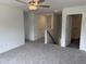 Bright living room featuring neutral carpeting, a ceiling fan, and multiple doorways and hallways at 4012 Kingcraig Ln, Zebulon, NC 27597