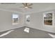 A spacious bedroom with three windows, plush carpet, a ceiling fan, and trim at 4012 Kingcraig Ln, Zebulon, NC 27597