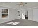 A large bedroom with three windows, plush carpet, and a ceiling fan at 4012 Kingcraig Ln, Zebulon, NC 27597