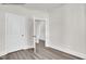 An airy room with white walls, light base trim, hardwood floors, and a partial door opening at 4012 Kingcraig Ln, Zebulon, NC 27597