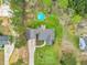Bird's eye view of the home featuring a backyard pool, long driveway, and verdant trees at 402 Womble Dr, Lillington, NC 27546