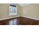 This bedroom has hardwood floors and a large window at 402 Womble Dr, Lillington, NC 27546