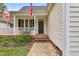 Welcoming front porch with cozy seating, classic columns, and American flag, creating a charming entrance at 402 Womble Dr, Lillington, NC 27546