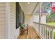 Charming front porch with wooden bench, decorative pillows, and classic columns, ideal for relaxation at 402 Womble Dr, Lillington, NC 27546