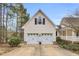 Spacious two-car garage with an upper window and adjacent covered porch, perfect for parking and outdoor access at 402 Womble Dr, Lillington, NC 27546