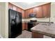 Kitchen with brown cabinets and black appliances at 402 Womble Dr, Lillington, NC 27546