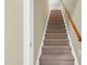 Carpeted staircase leading to the upper level with wood railing at 402 Womble Dr, Lillington, NC 27546